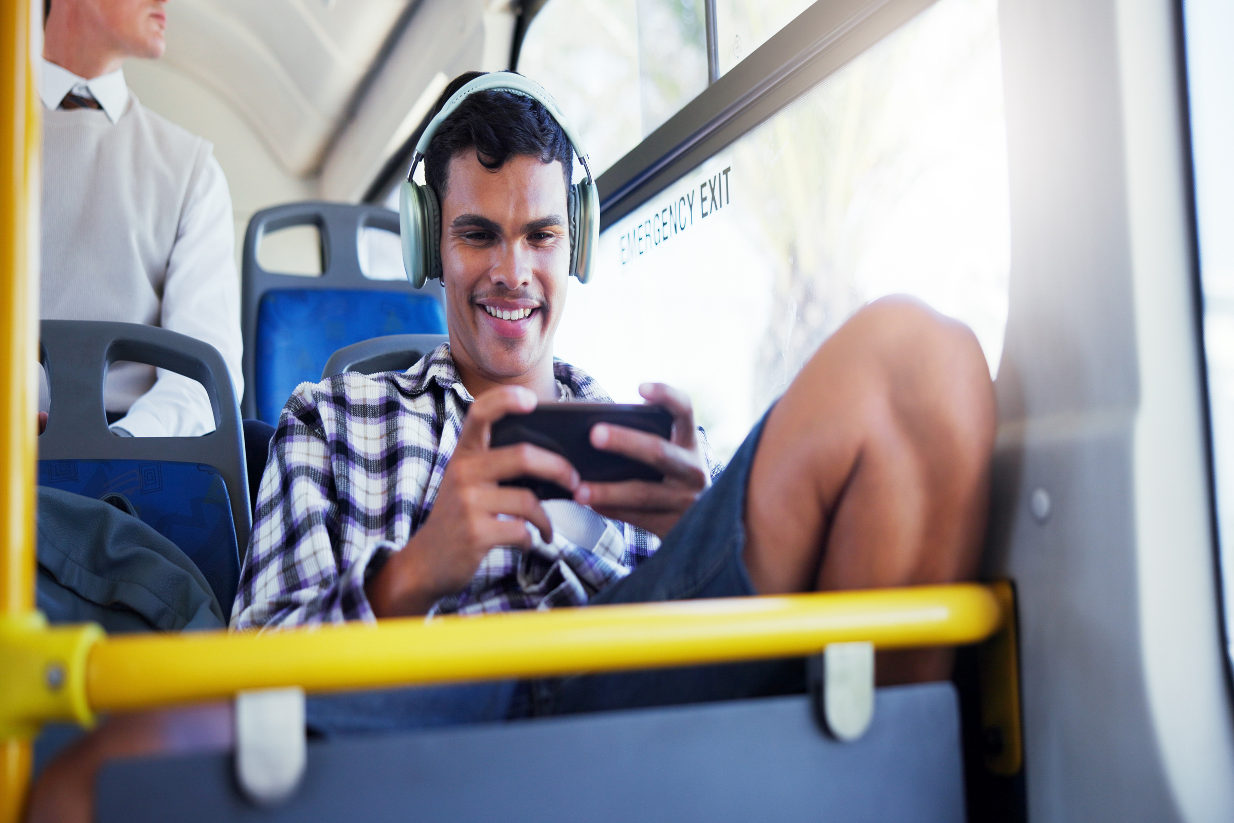 Mężczyzna oglądający film na smartfonie Realme GT 6 w autobusie