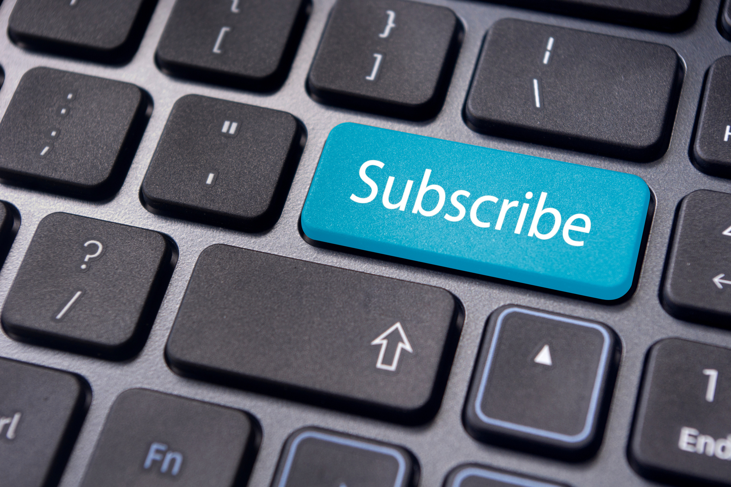 Klawiatura kamputera z niebieskim klawiszem z napiszem "Subscribe"
