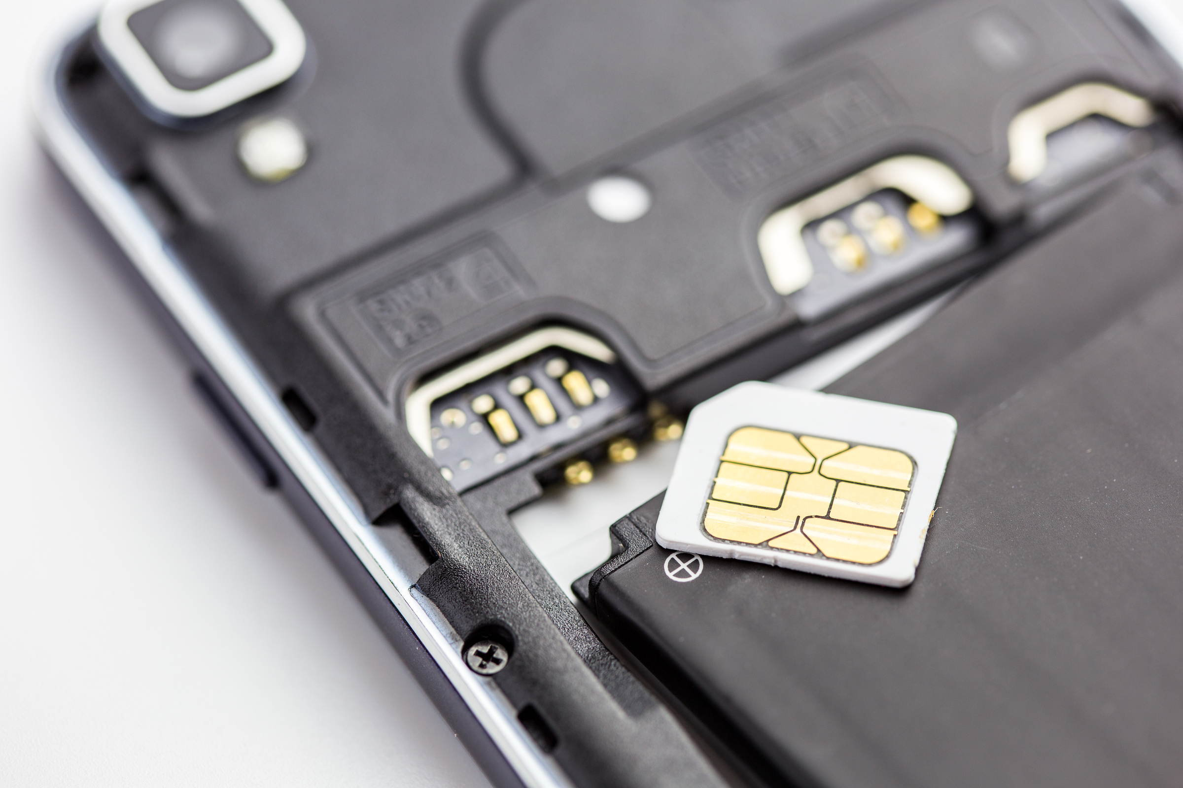 Rozłożony na części smartfon z kartą SIM na baterii.