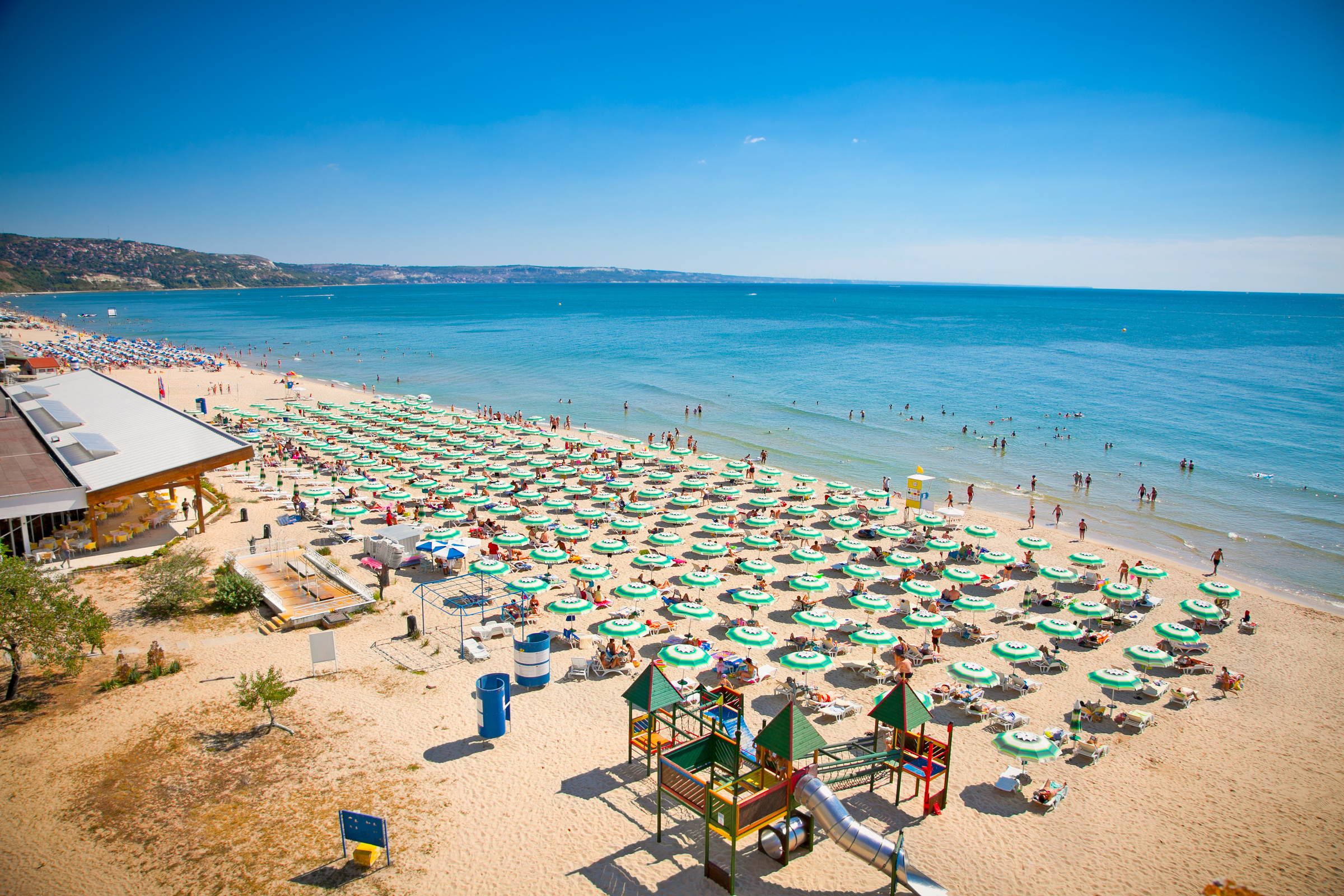 Widok na słynną bułgarską plażę Słoneczny Brzeg nad Morzem Czarnym, wypełnioną rzędami parasoli i wypoczywającymi ludźmi