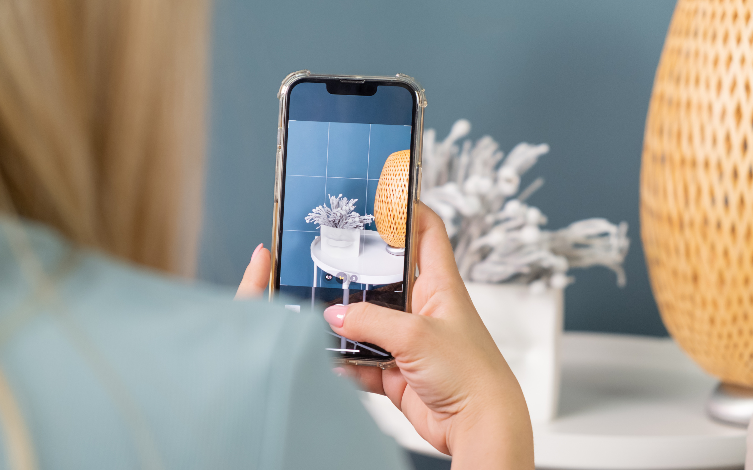 Kobieta robi zdjęcie z pomocą smartfona iPhone 17 Air