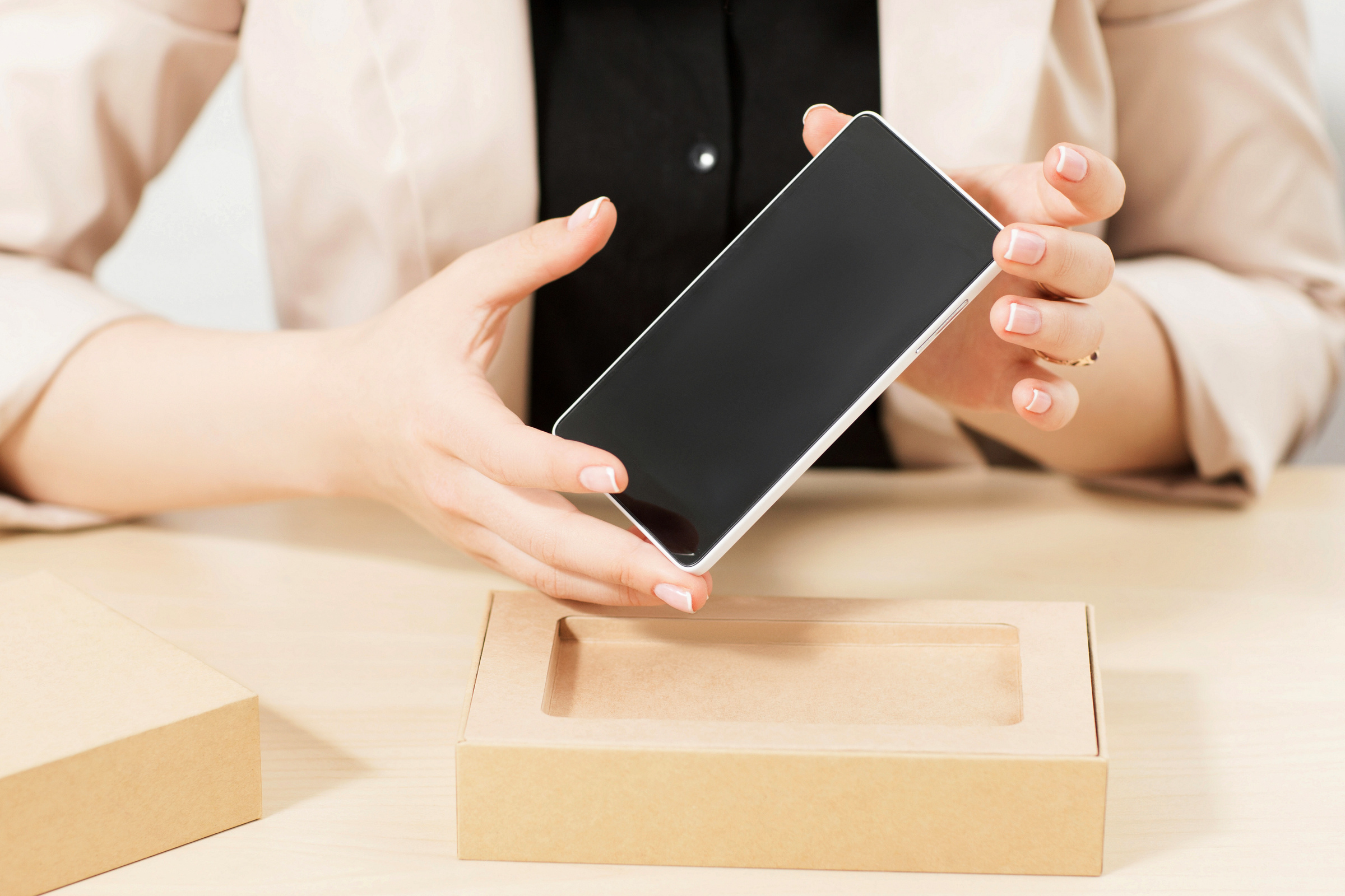 Kobieta trzyma w dłoniach nowy, wyciągnięty z pudełka smartfon OPPO Find X8 Pro