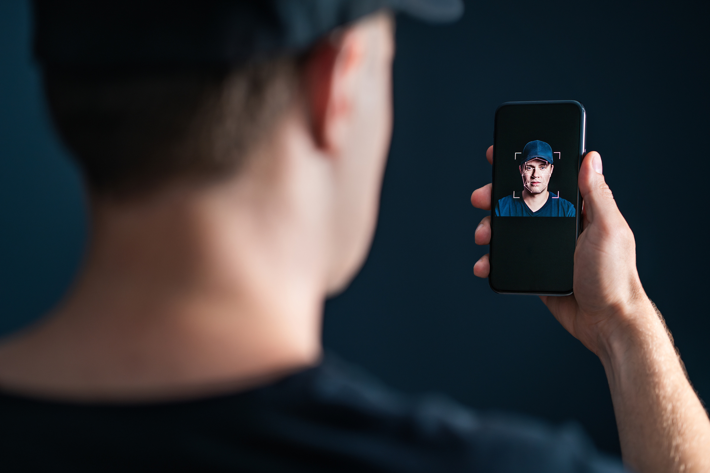 Mężczyzna trzyma w ręku smartfon OPPO Find X8 Pro z włączoną funkcją rozpoznawania twarzy