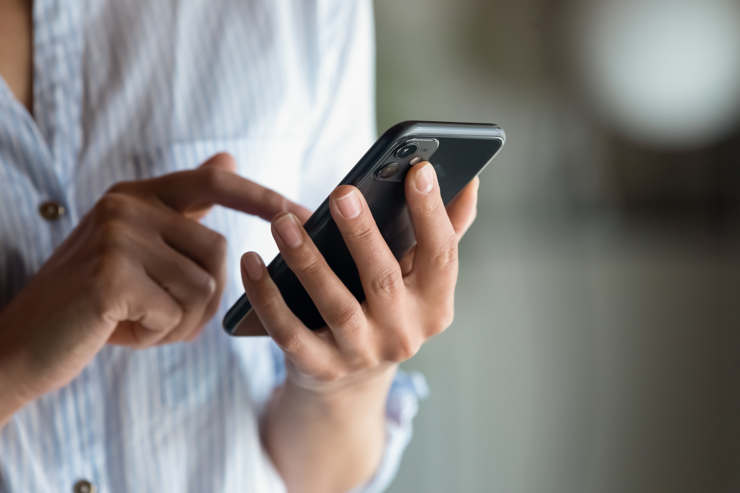 Kobieta trzyma w ręce smartfona Realme GT7 PRO i przesuwa palcem po ekranie