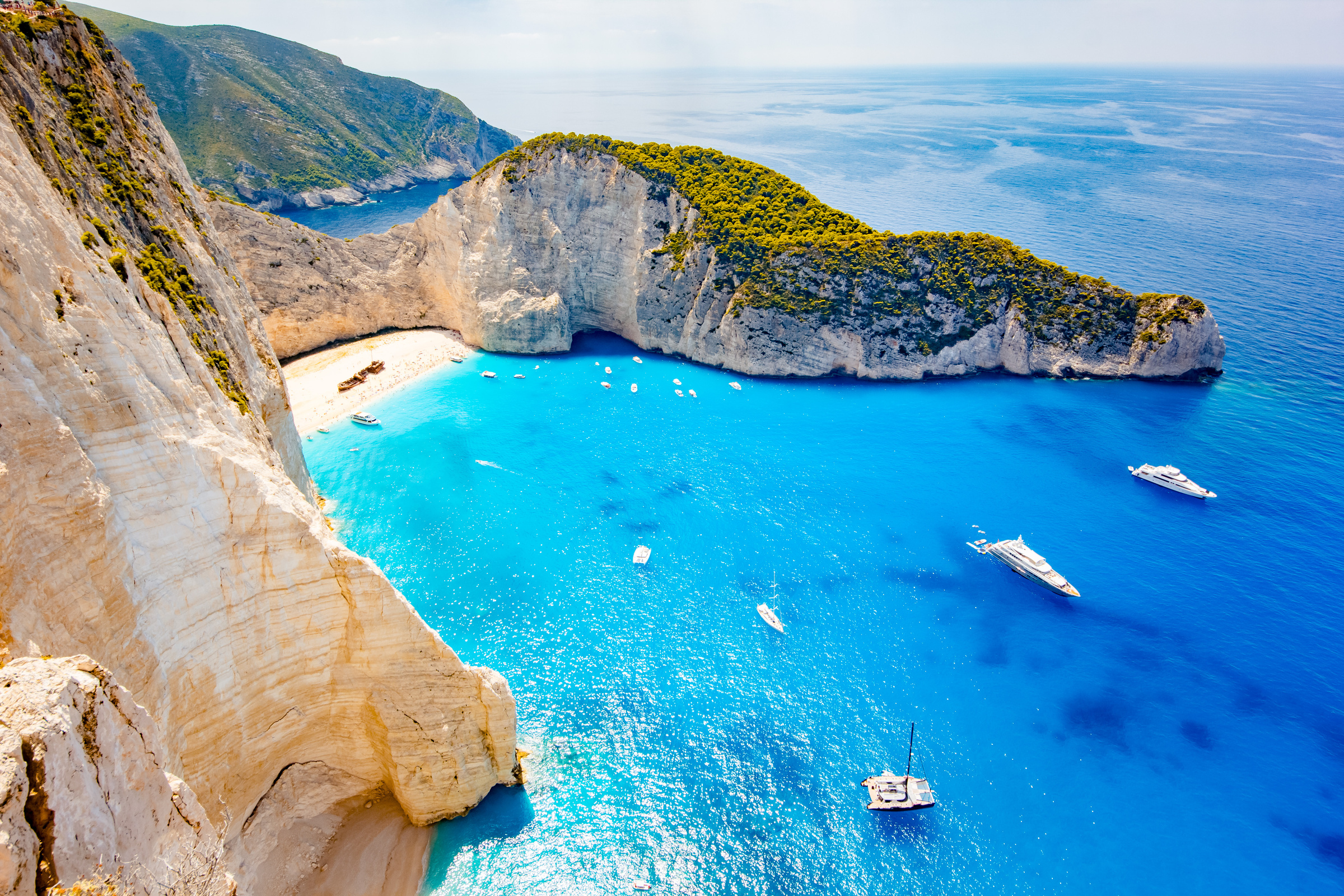 Widok z lotu ptaka na plażę Navagio na greckiej wyspie Zakynthos, z białym piaskiem i wrakiem statku otoczonym wysokimi klifami