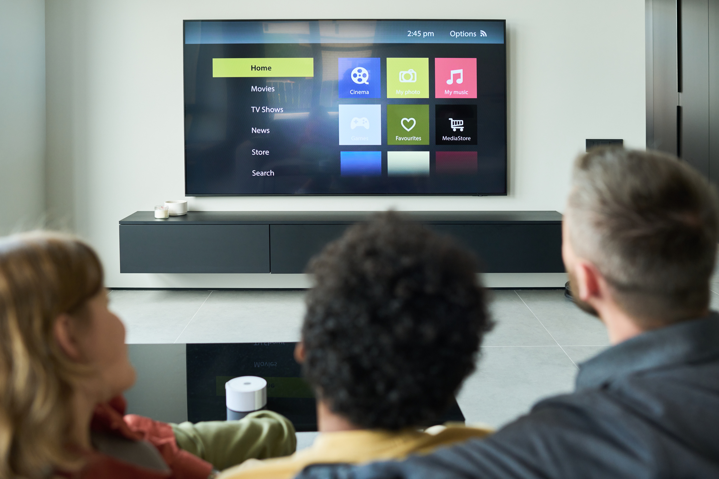 Rodzina siedzi na kanapie, oglądając telewizor z AI
