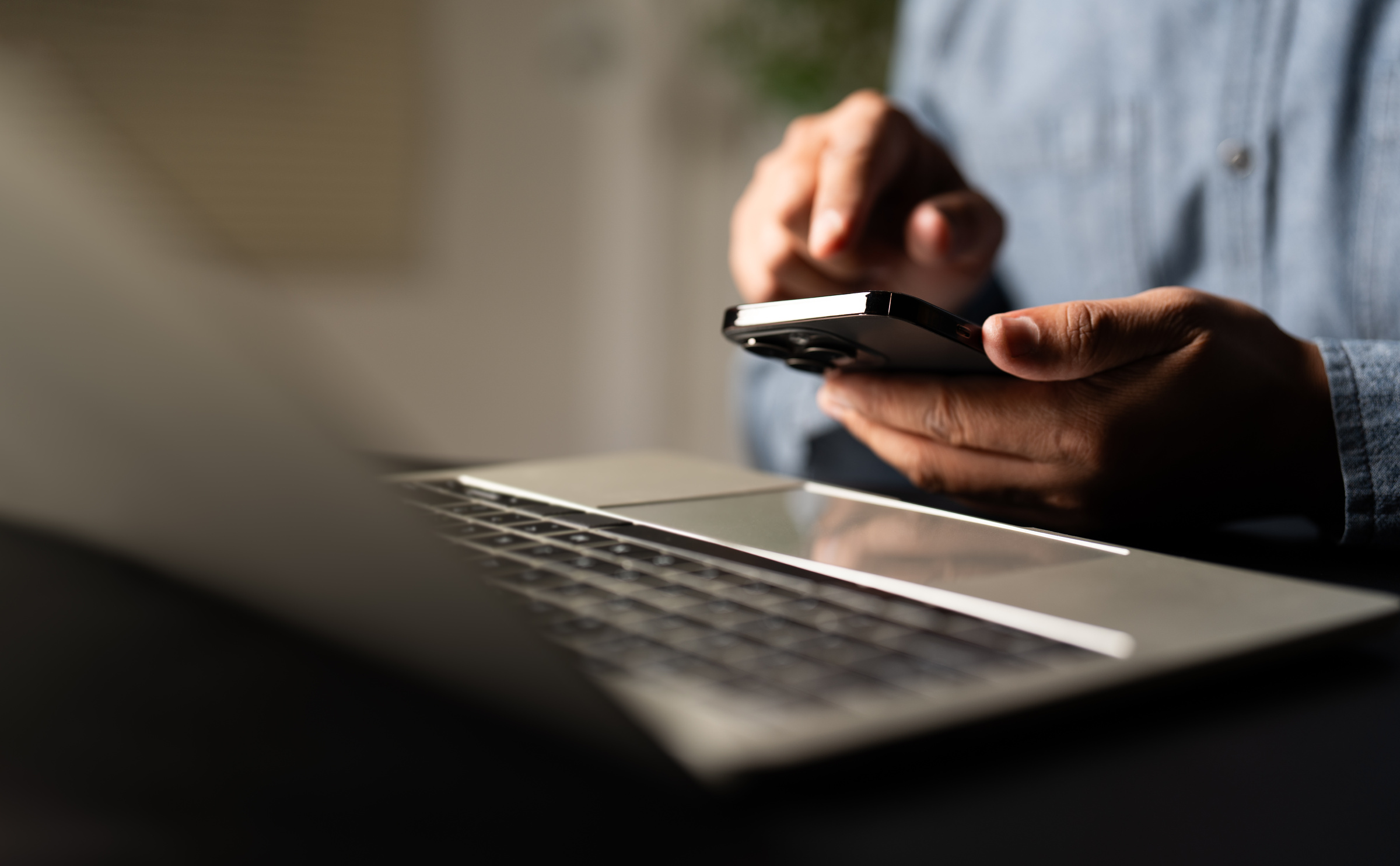 Mężczyzna za pomocą smartfona udostępnia internet na kartę, aby korzystać z laptopa