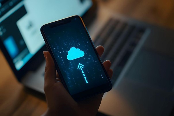 Chmura ze strzałką na ekranie smartfona symbolizująca przesyłanie informacji.