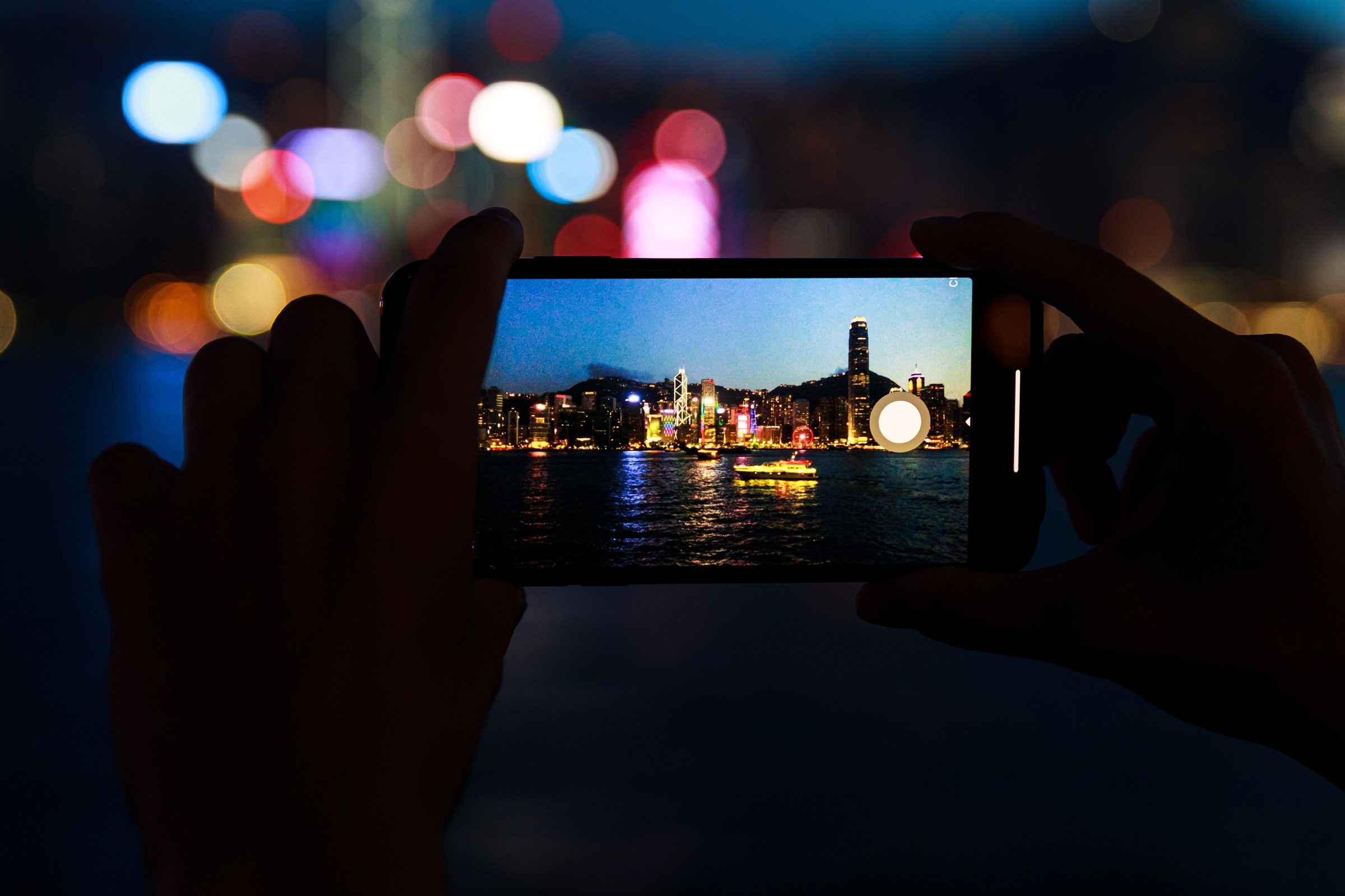 Człowiek wykonuje fotografie nocne przy użyciu nowoczesnego smartfona