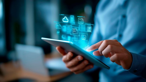 Osoba pisząca na tablecie, nad którym wyświetlają sie ikonki symbolizujące bezpieczeństwo.