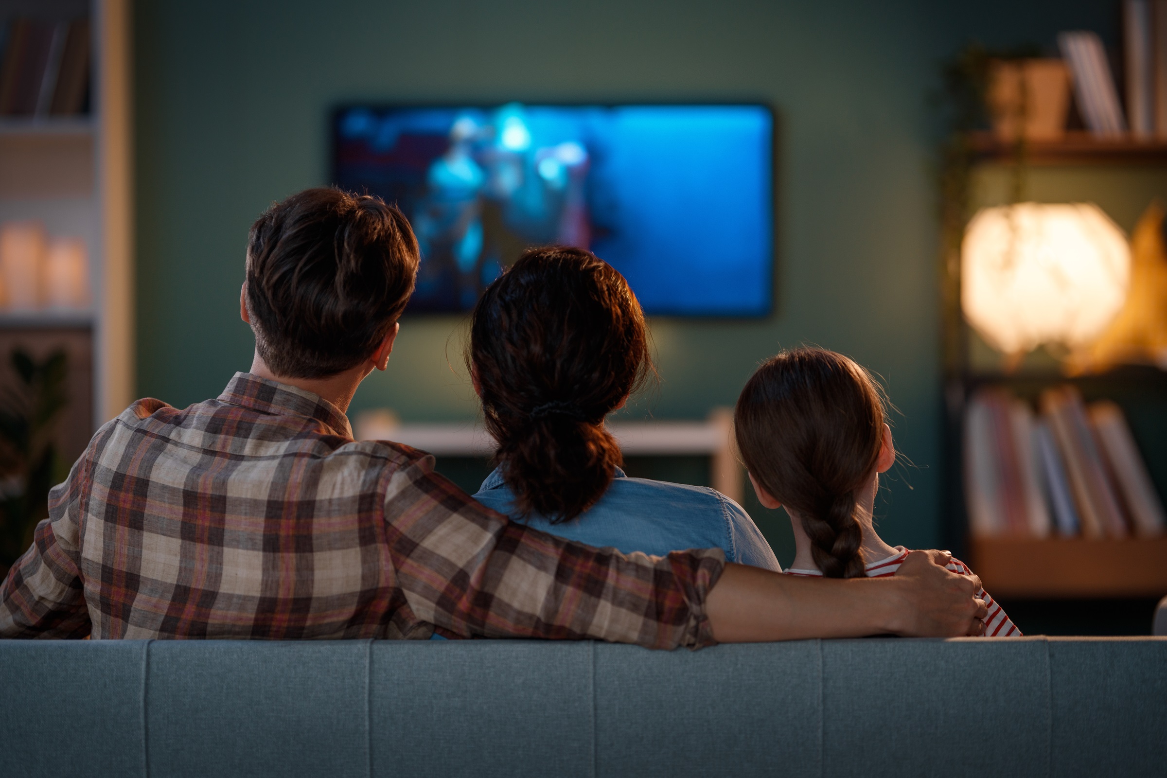 Rodzina siedząca w salonie i oglądająca Telewizję Nowej Generacji