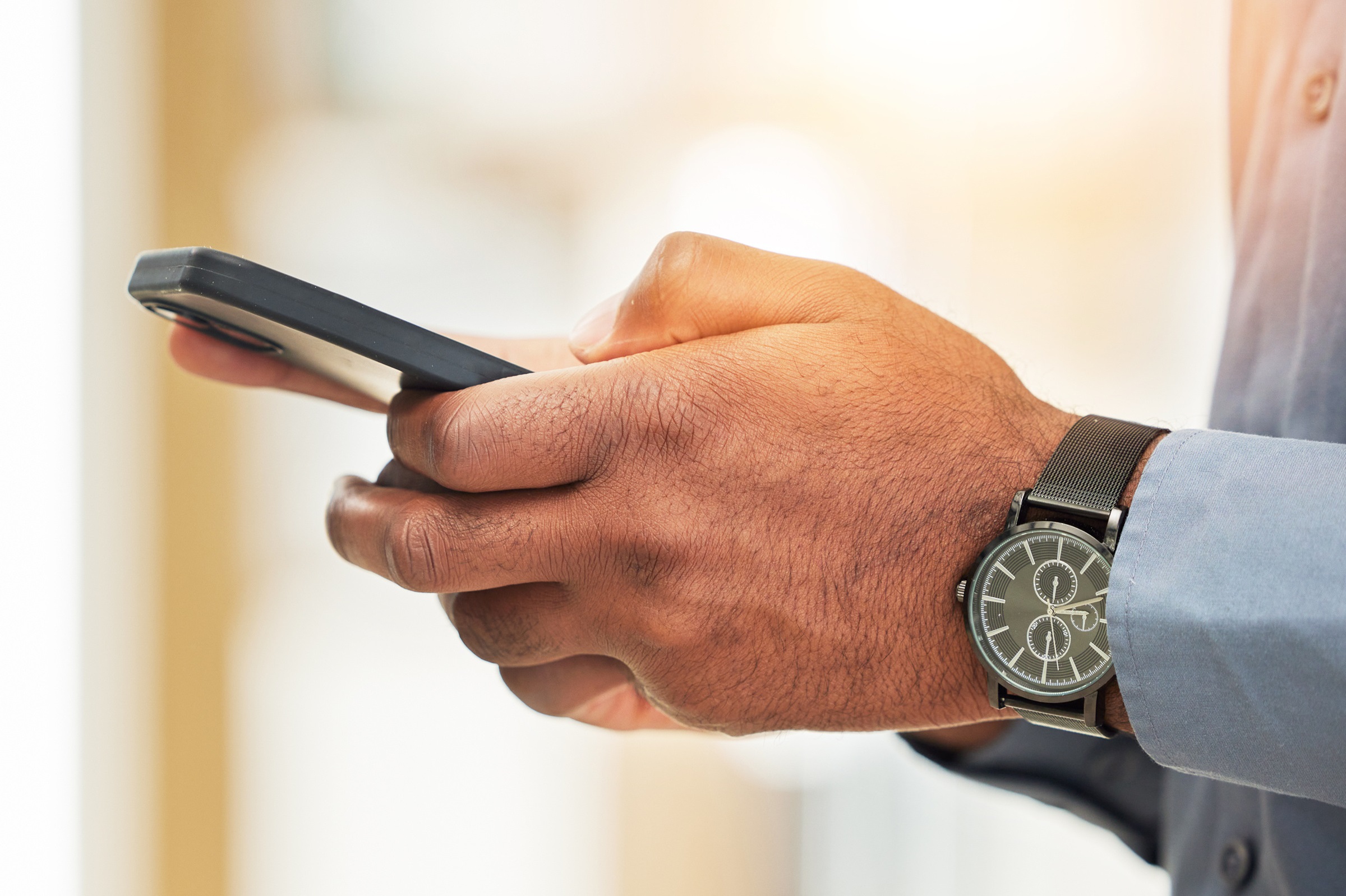 Smartfon w dłoniach mężczyzny.