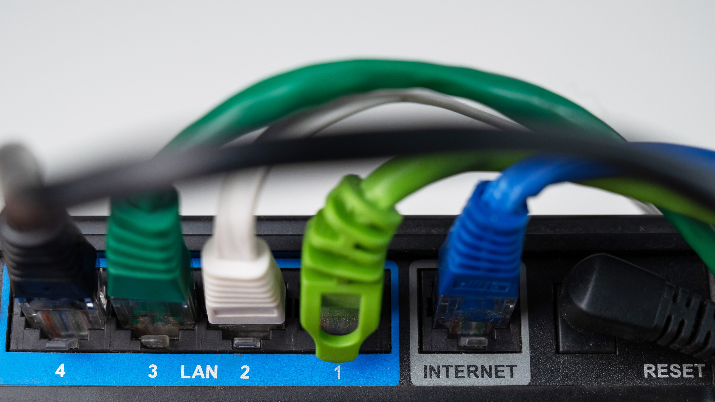 Router, do którego włożone są kable internetowe. 