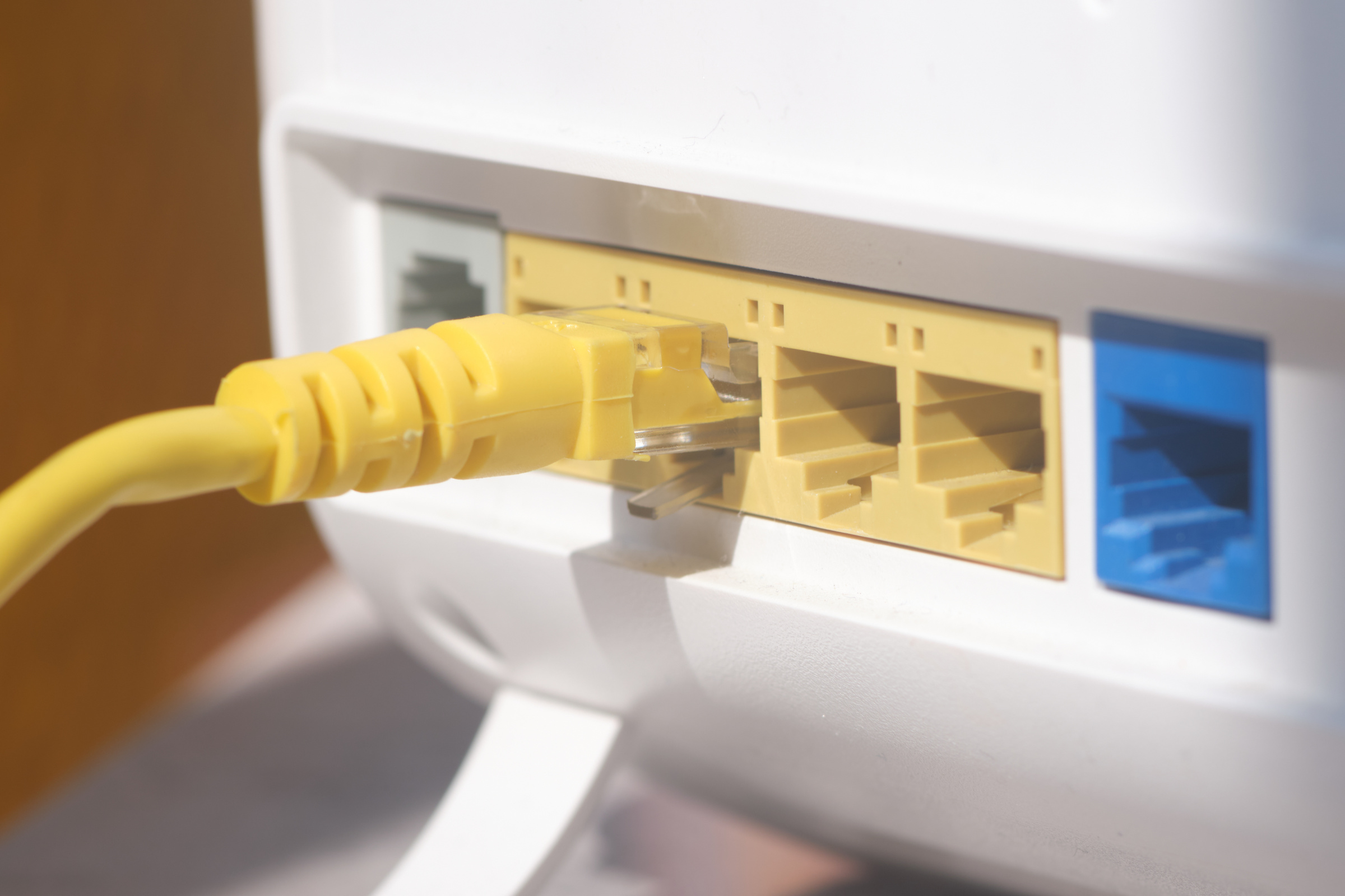 Router, do którego włożony jest kabel internetowy.