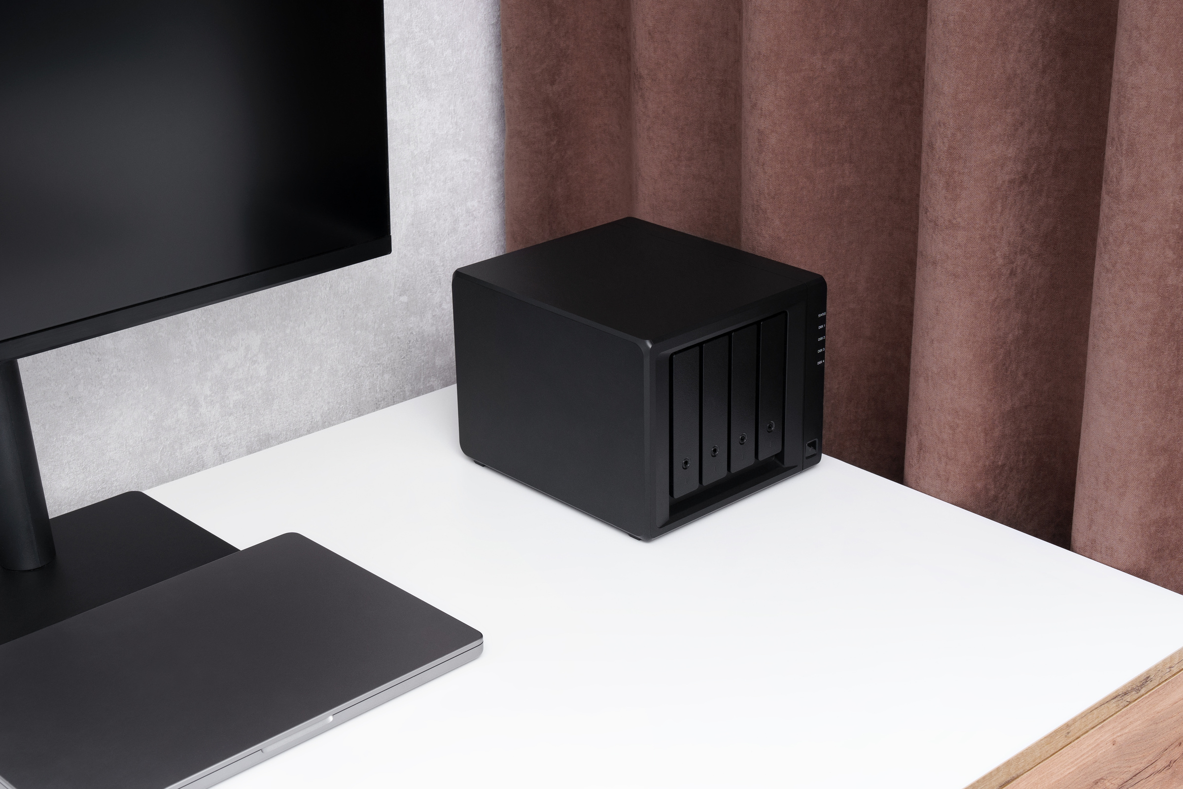 Serwer NAS stoi na biurku obok komputera