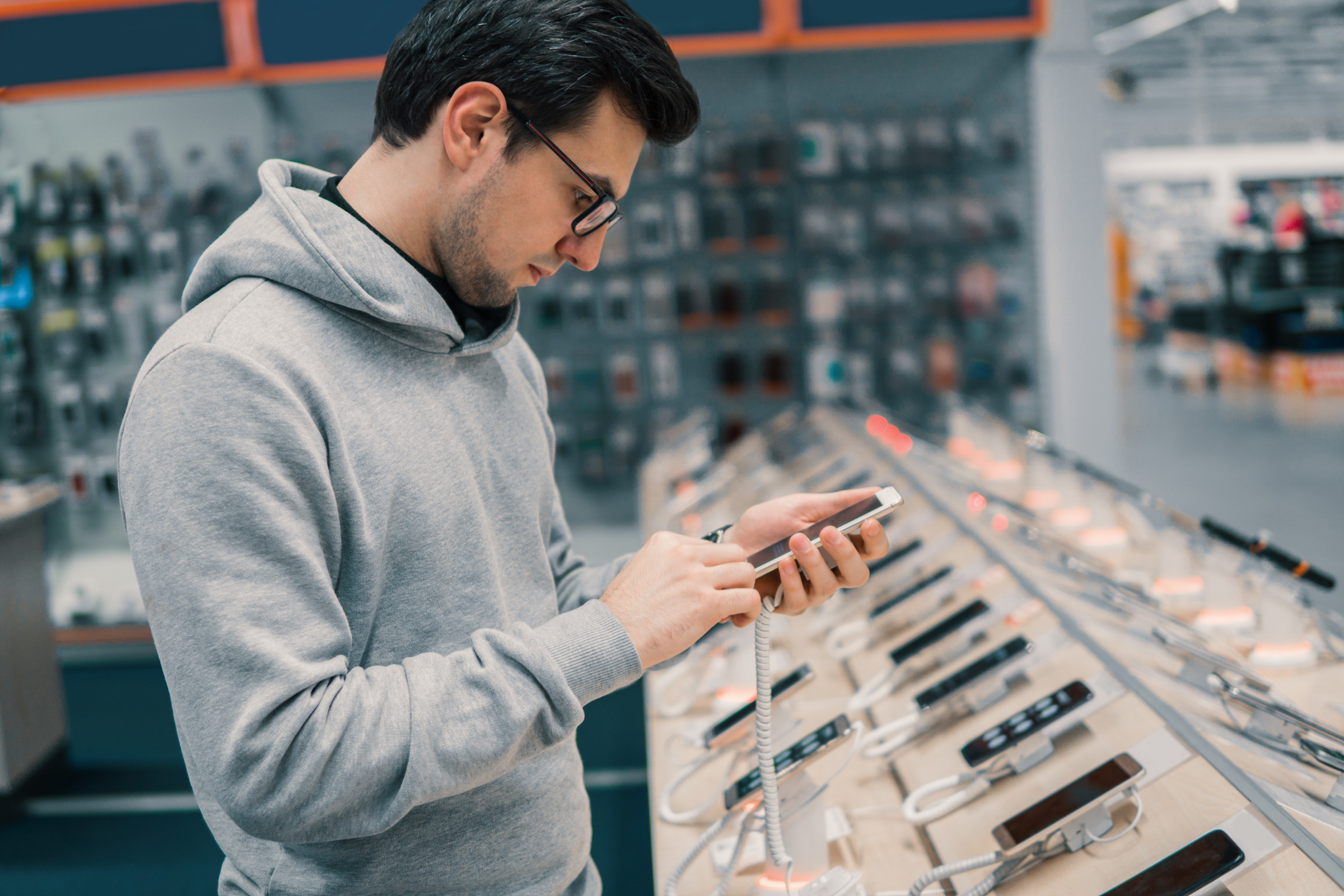 Mężczyzna wybierający smartphone w salonie