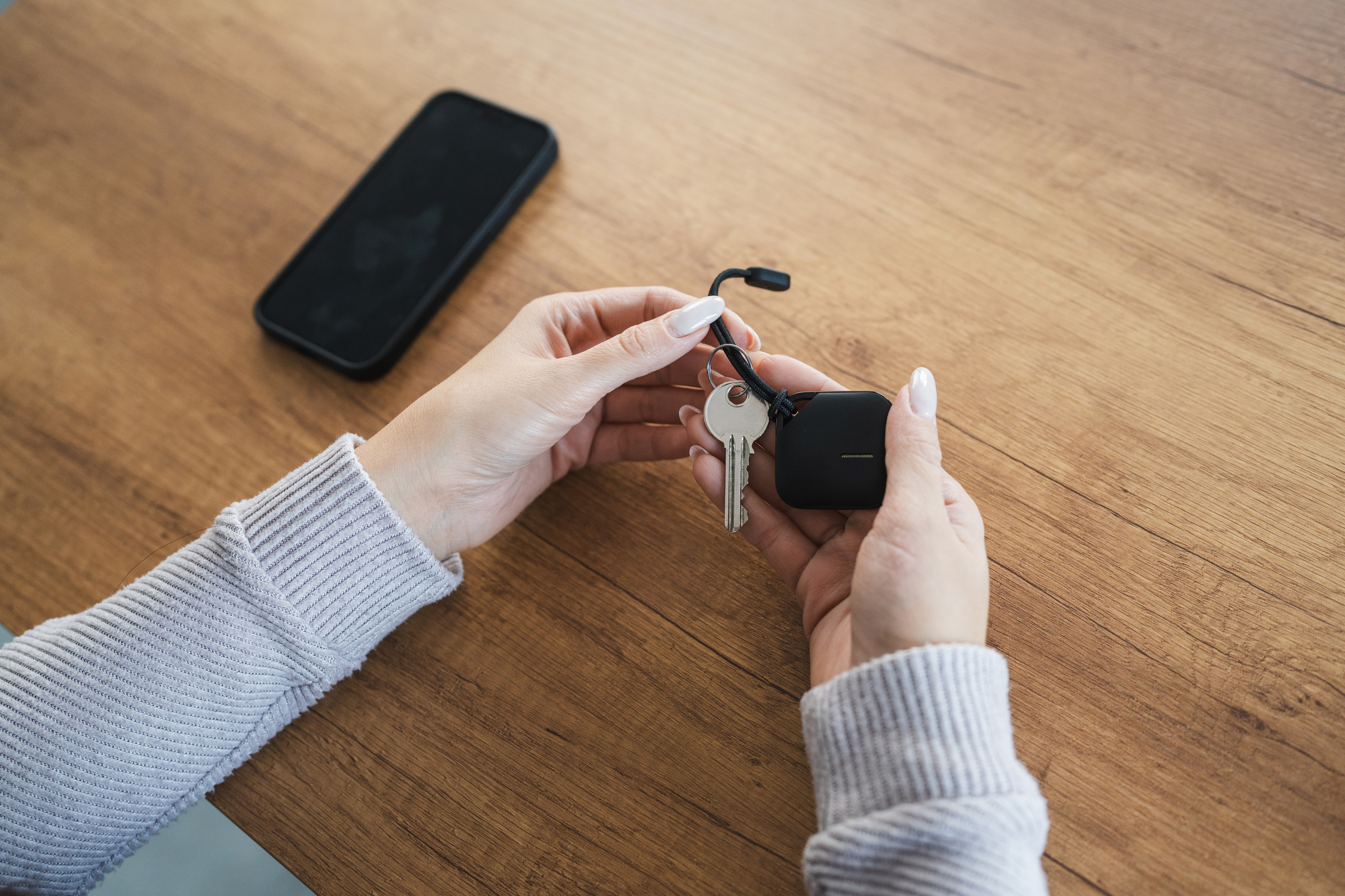 Kobieta przypina lokalizator do kluczy