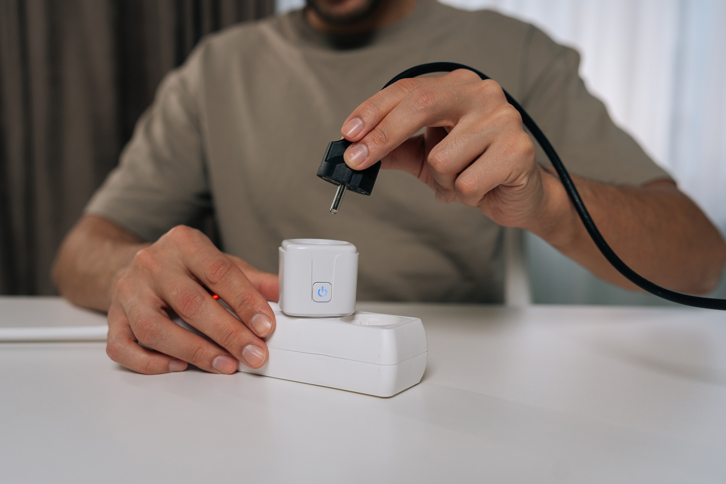 Mężczyzna podłącza urządzenie do inteligentnego gniazdka