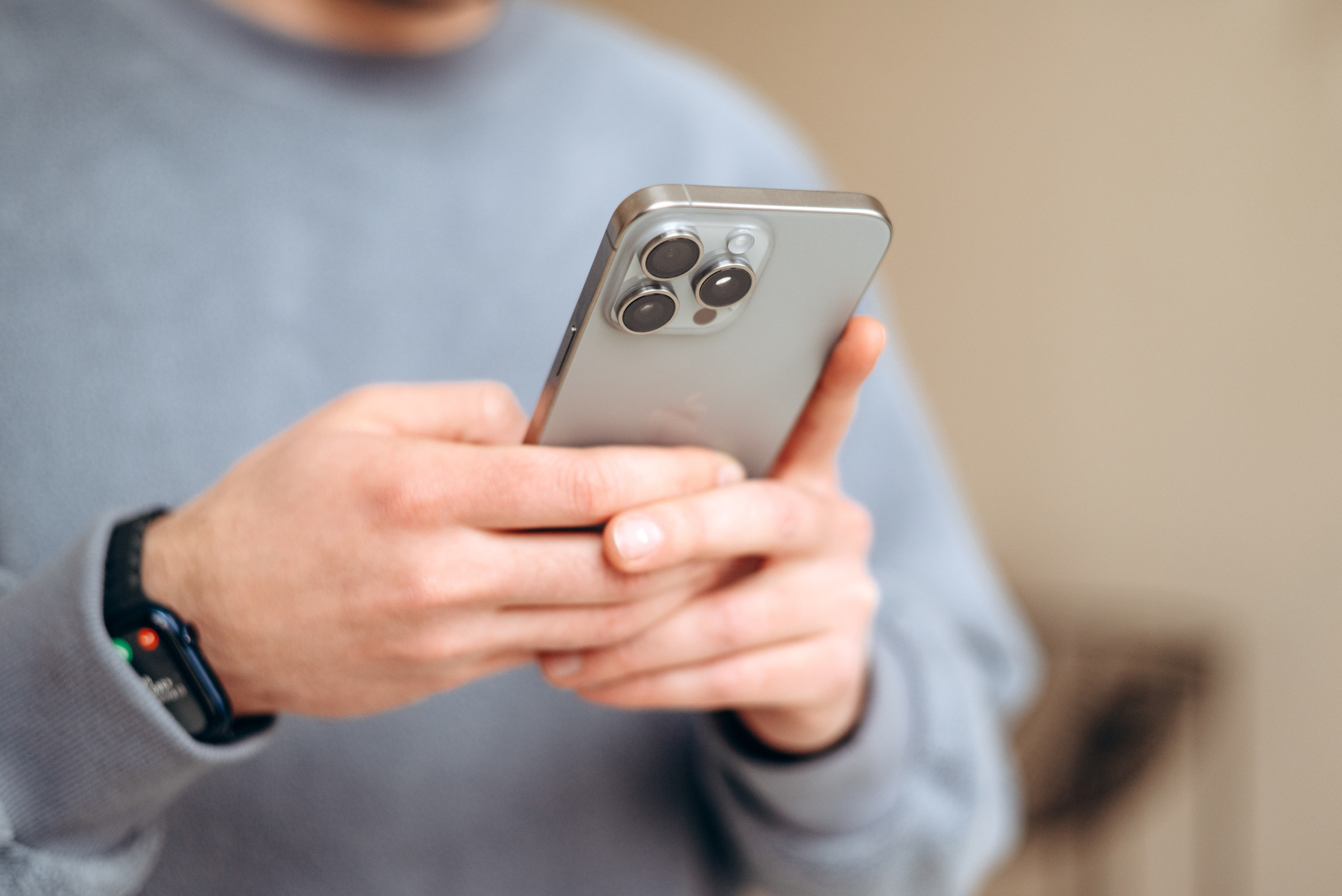 Mężczyzna korzystający z telefonu iPhone w srebrnym kolorze 