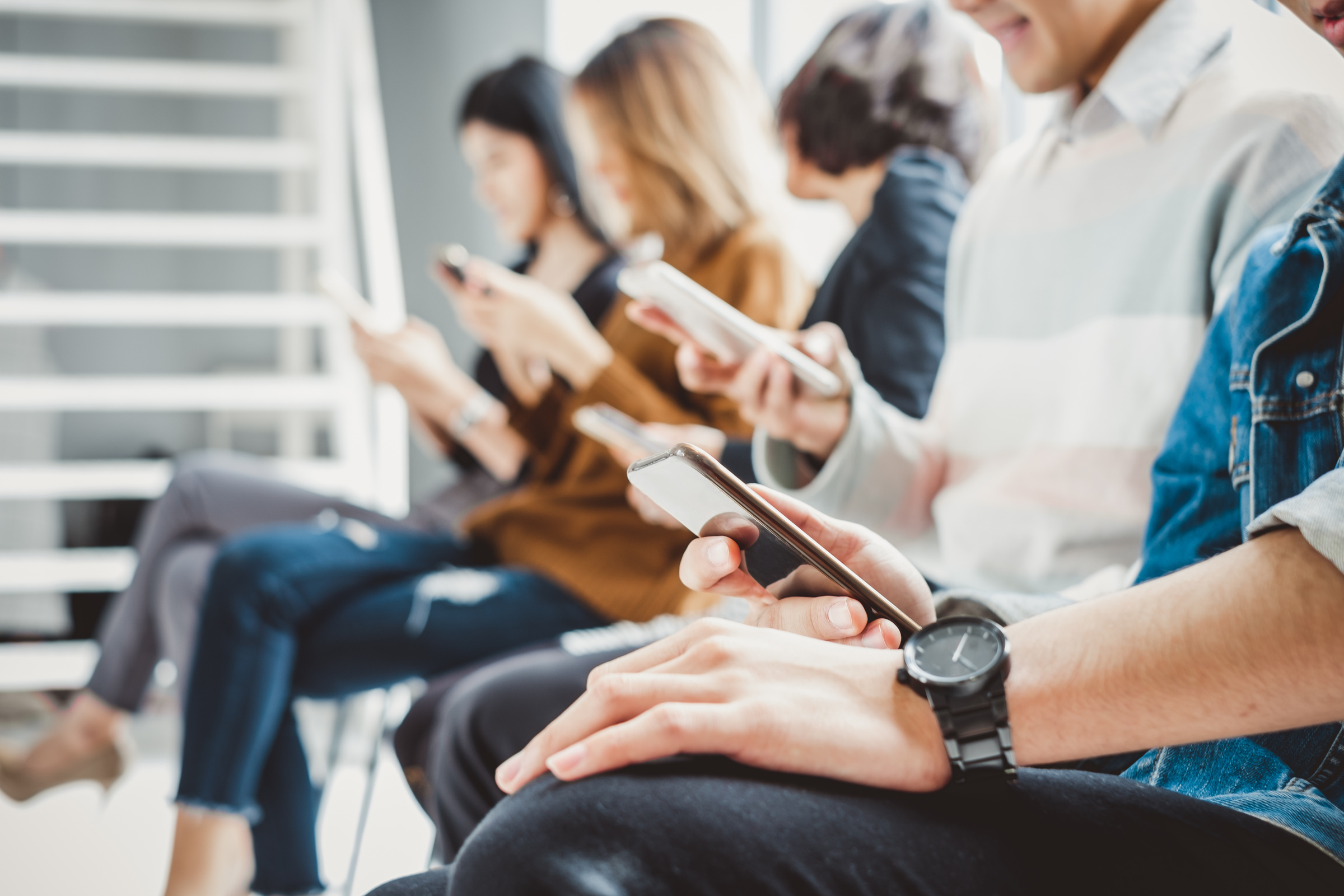 Grupa znajomych korzystająca z telefonów podczas spotkania
